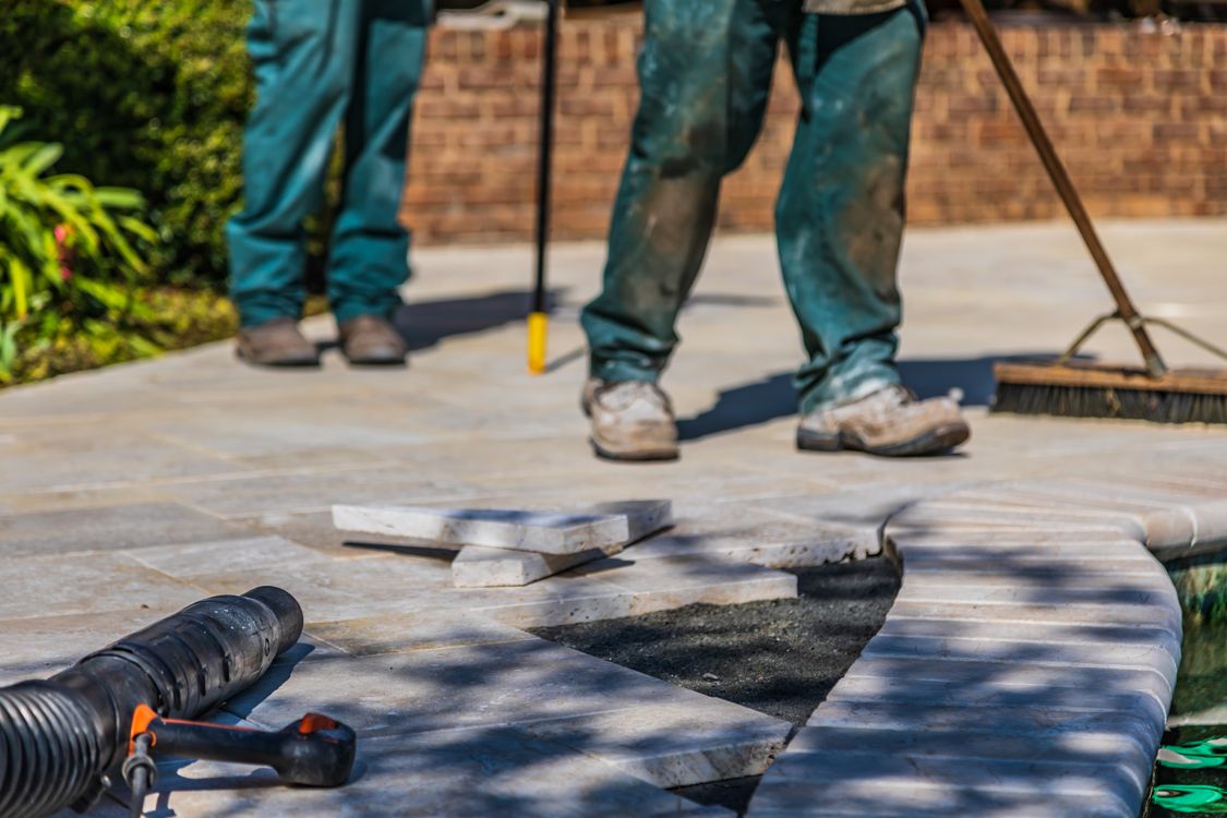 Laufende Verlegung von Terrassenplatten mit Werkzeugen und offenen Stellen